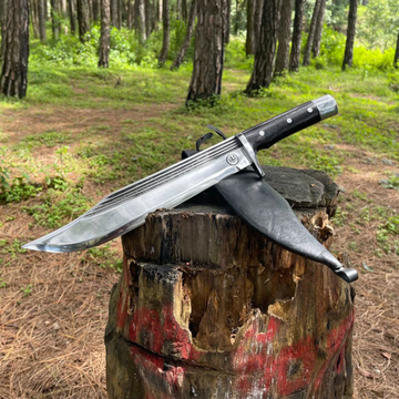 11 inch bowie knife in wooden log beside black leather sheath